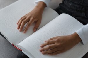 A blind child's hands reading a Braille book.